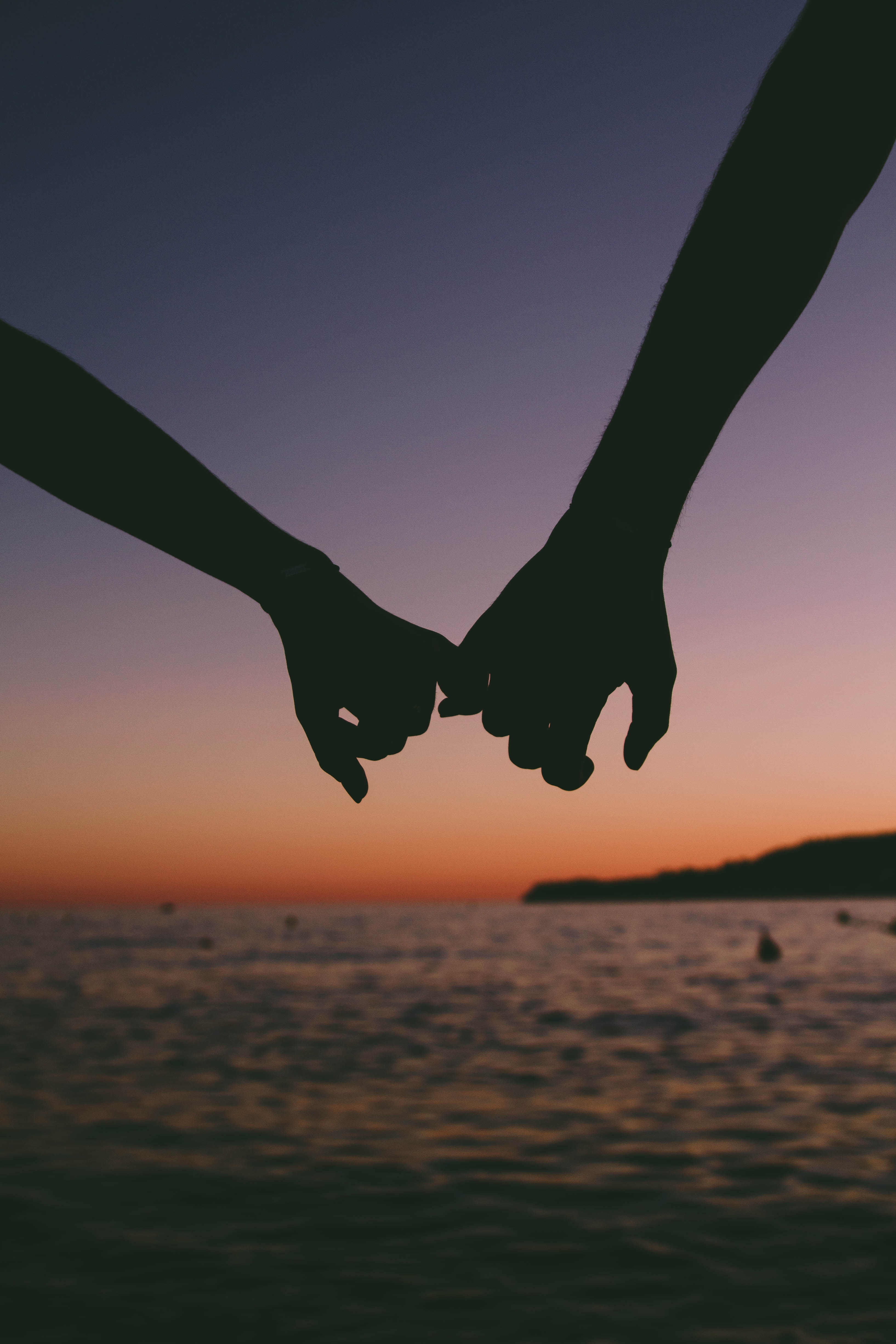 Couple holding hands with sunset