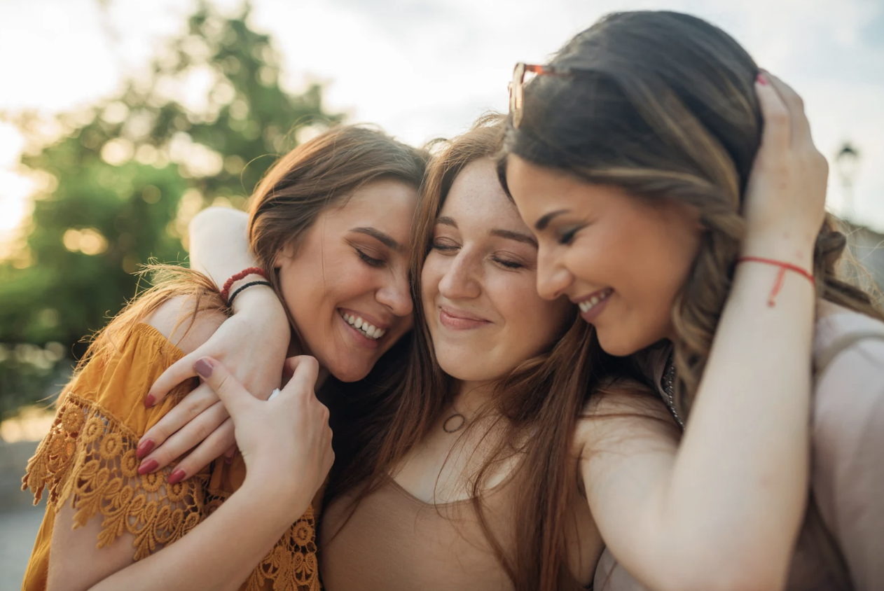 3 women hugging and smiling